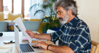 A man reading and using a laptop