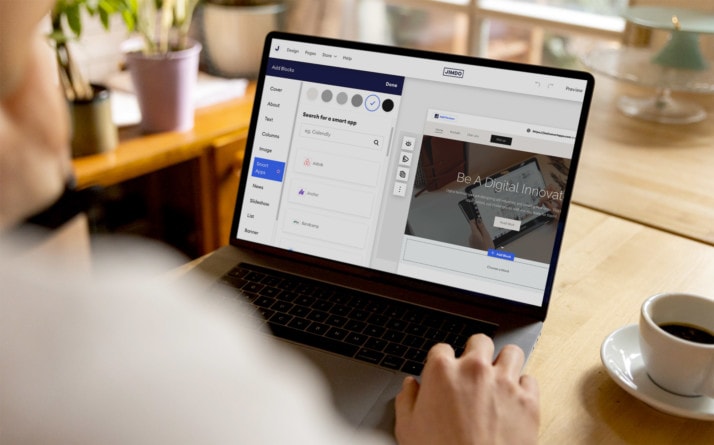 A person at a laptop adding Smart Apps to their Jimdo website.