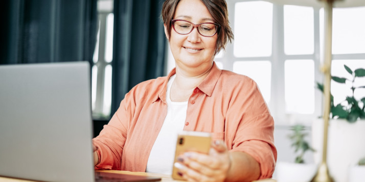 Eine Frau vergleicht den Look ihrer DIY-Website auf Laptop und Smartphone