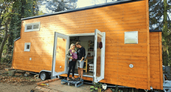 Max mit seiner Partnerin und Tochter vor seinem Tiny House