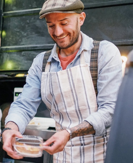 Man serves up a takeout meal ordered by a customer on his ecommerce website