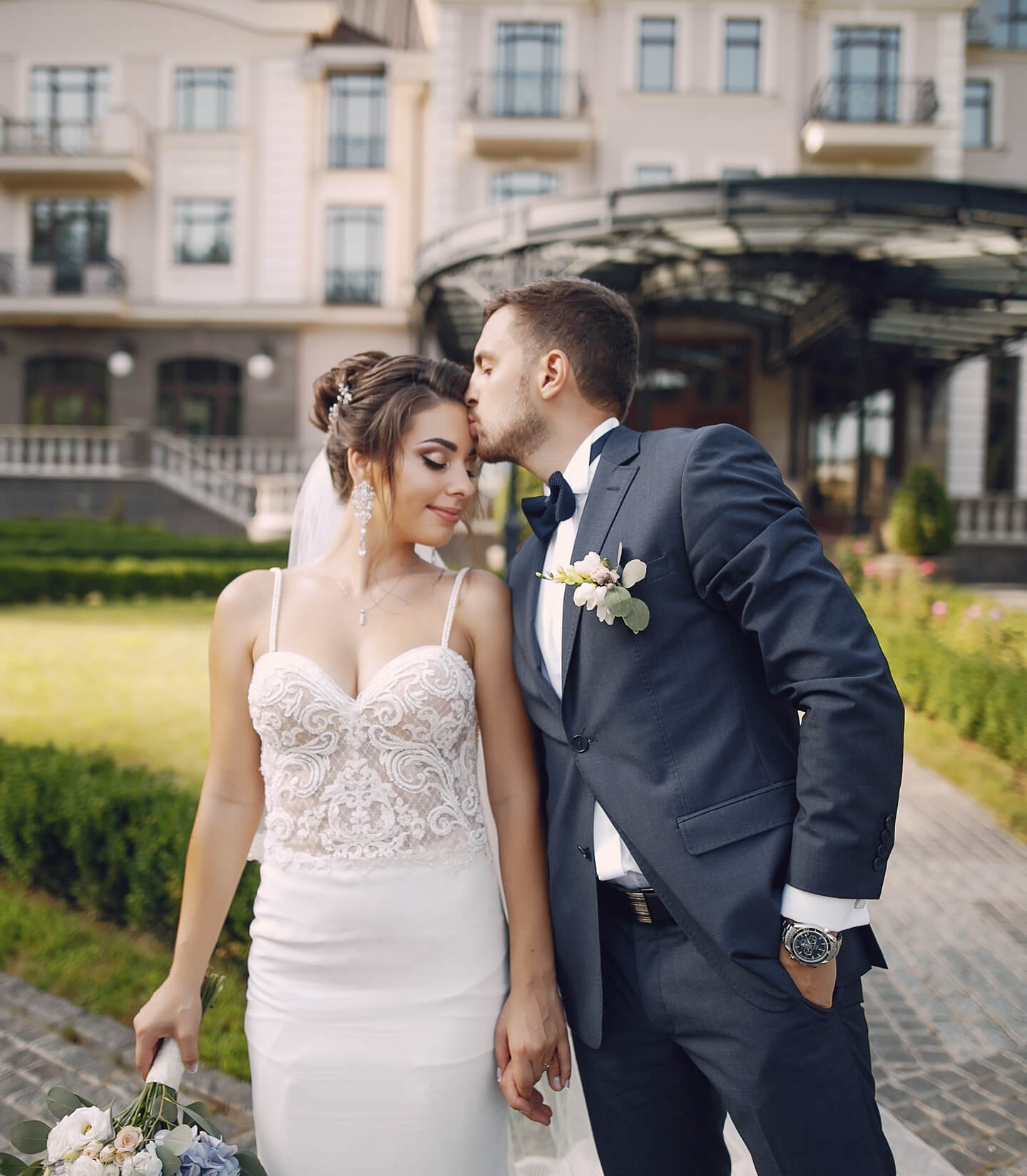 Una pareja recién casada posa en los exteriores de donde se celebra la boda.