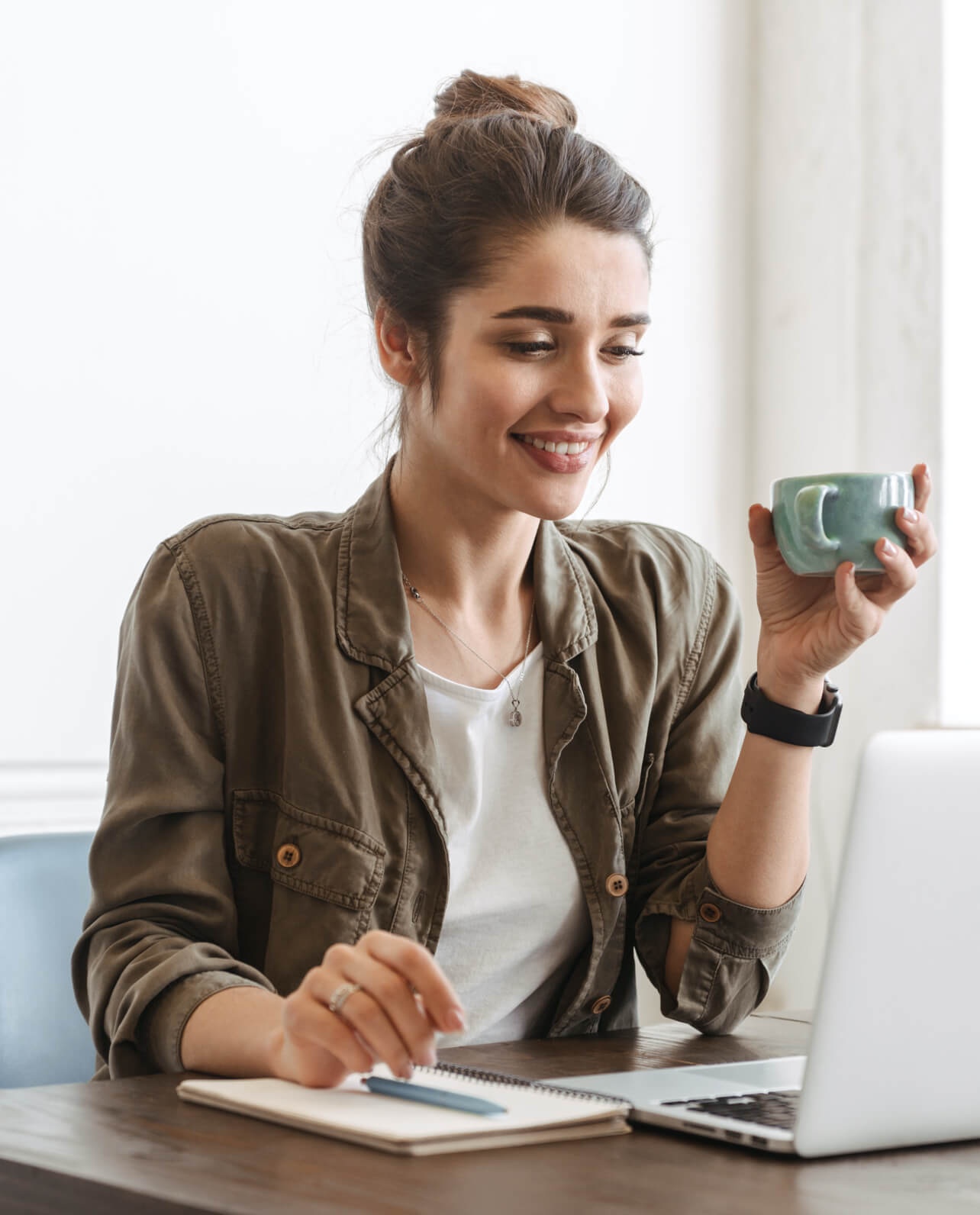 Eine junge Frau sitzt an ihrem Laptop und arbeitet an ihrer Vereinshomepage